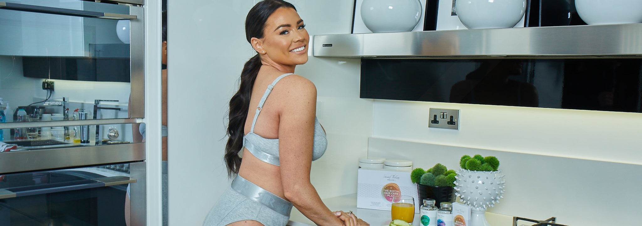 Jessica Wright smiling in the kitchen with her Simone Thomas Wellness supplement range