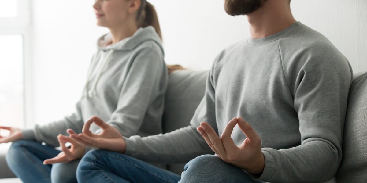 Young couple meditating to improve mental wellness and help hair loss
