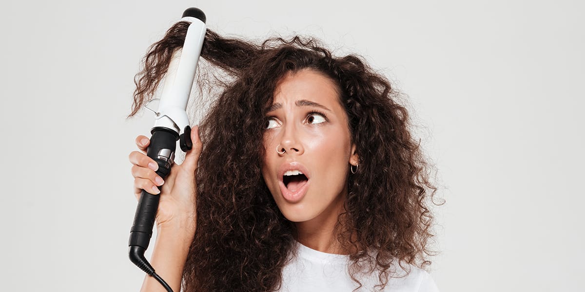 Lady confused as she curls her hair with heated hair products