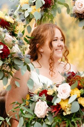 A bride holding a bridal bouquet in autum colours