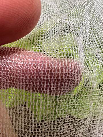 InsectoNet insect netting with hand running through it to show material and visibility through net