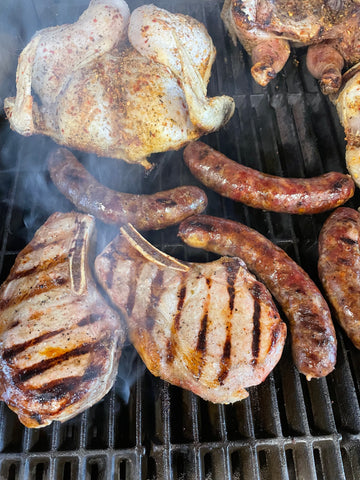 Sonny's Farm regeneratively farmed meats on the grill, including pastured chicken, heritage pork sausage, heritage pork chops.
