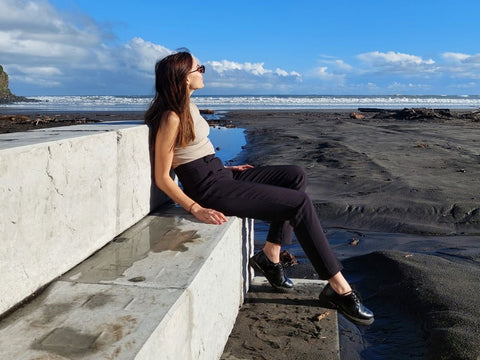 Young Woman Sitting on Stonebloc Seated Seawall on Opunake Beach