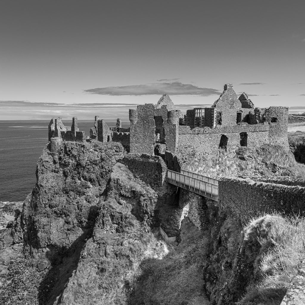 ic:Medieval Echoes: Dunluce Castle stands as a dramatic testament to Northern Ireland's storied past, perched precariously at the edge of the Antrim coast.