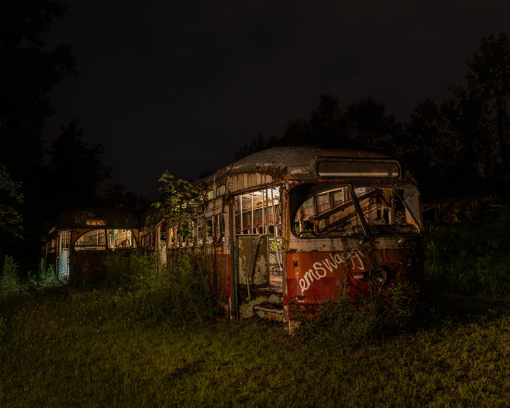 ic:Under the cloak of night, the skeletal frames of rusting streetcars emerge as haunting relics of urban decay, their once bustling existence now a ghostly presence in the stillness of abandonment.