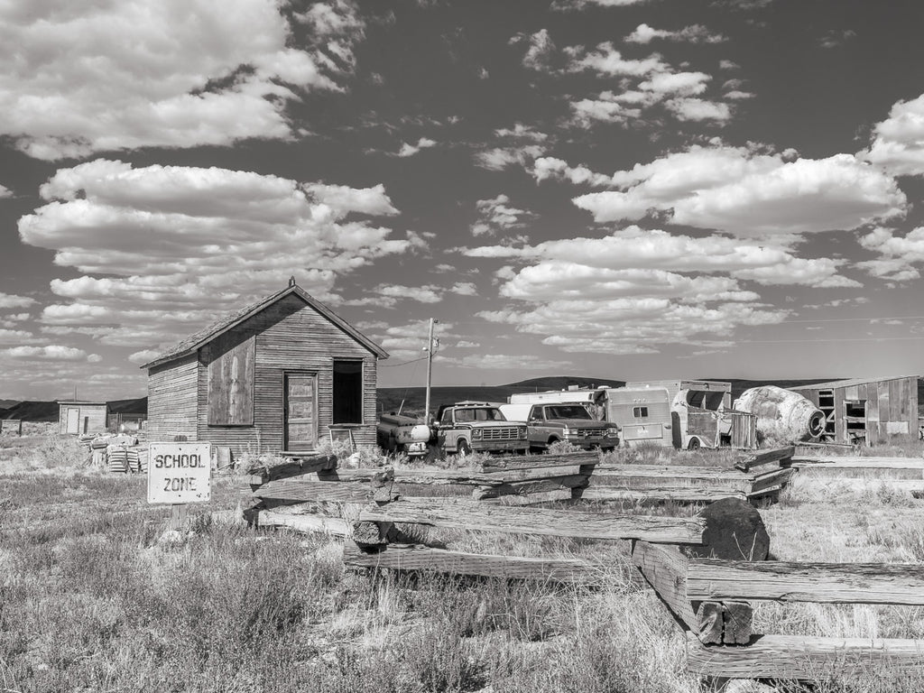 ic:Capturing the essence of abandonment and decay, this photograph showcases the lonely schoolhouse in the ghost town of Currie, Nevada, its empty halls whispering stories of a community long gone, a poignant symbol of educational and social eras faded into the sands of time.