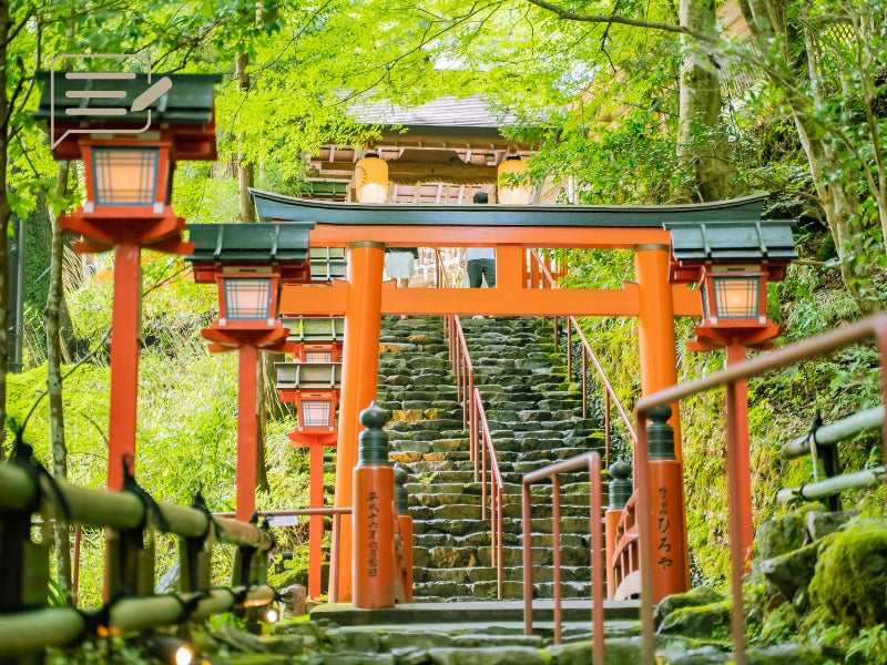 ic:A bright red Torii gate standing proudly along a stone pathway, leading visitors through a lush forest to a tranquil shrine.