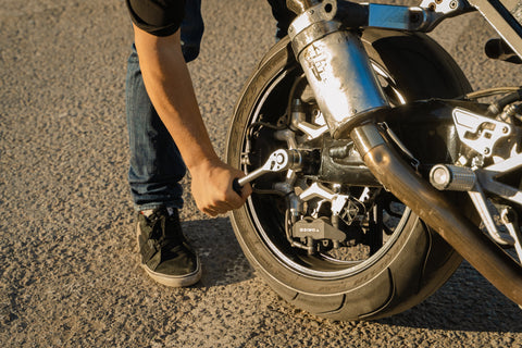 Man with socket wrench fixing motorcycle