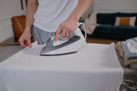 Man ironing white cloth