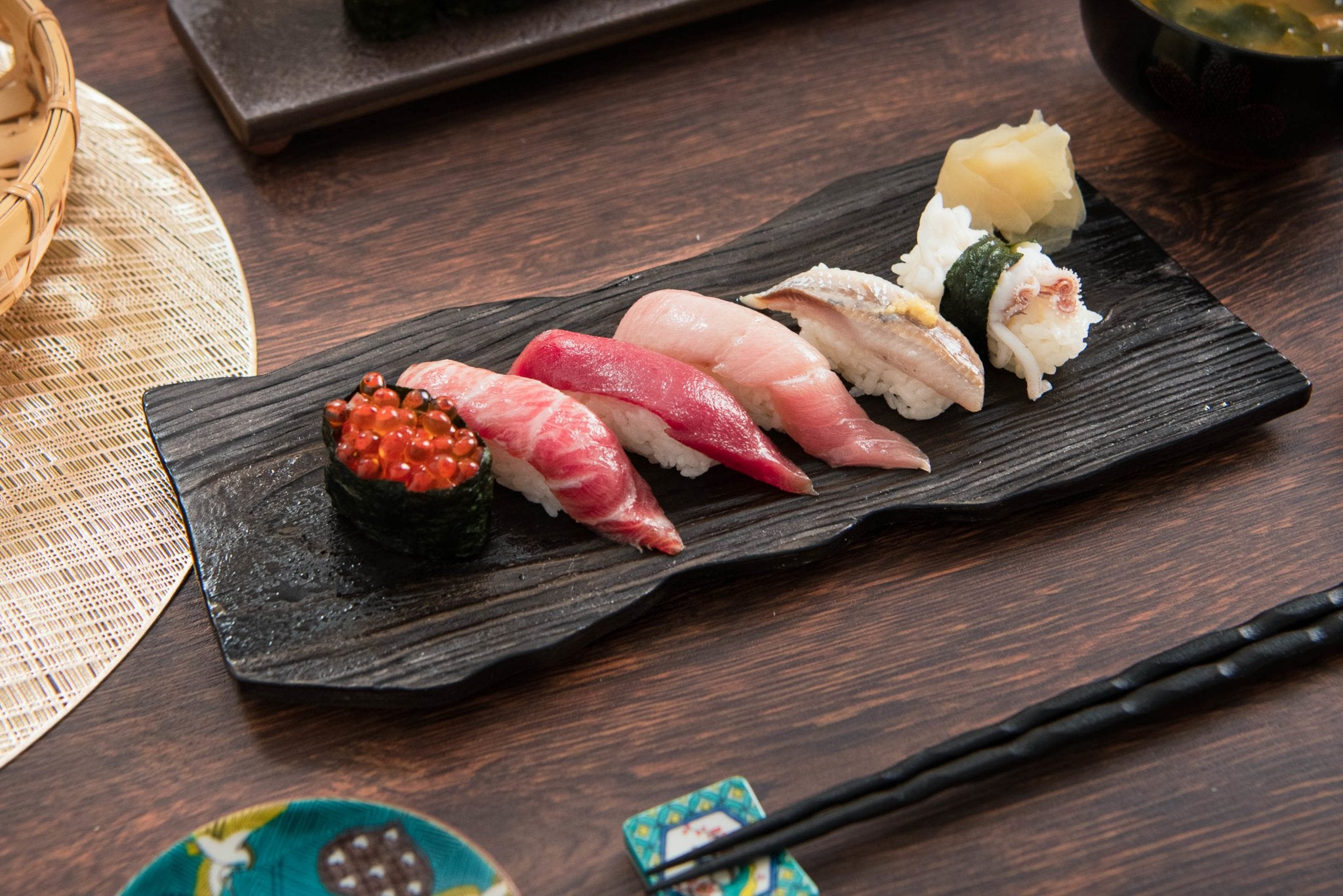 Japanese sushi set. Various types of roles on plate over stone