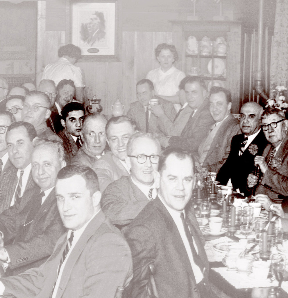 E.J. Audi is seated next to Leopold Stickley while his son Alfred sits opposite