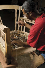 An SFU craftsman hand-knots a spring foundation