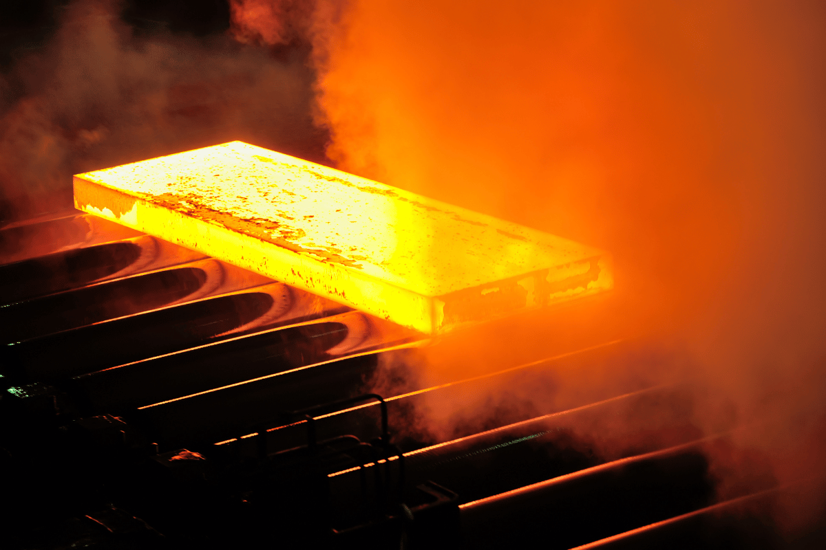 a rectangular piece of steel, red hot. this piece of steel is in the process of being hot rolled