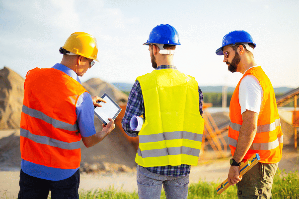 3 engineers discussing business outside an australian iron mine