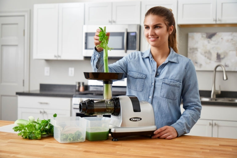 Women juicing celery in the Omega MM900 Juicer