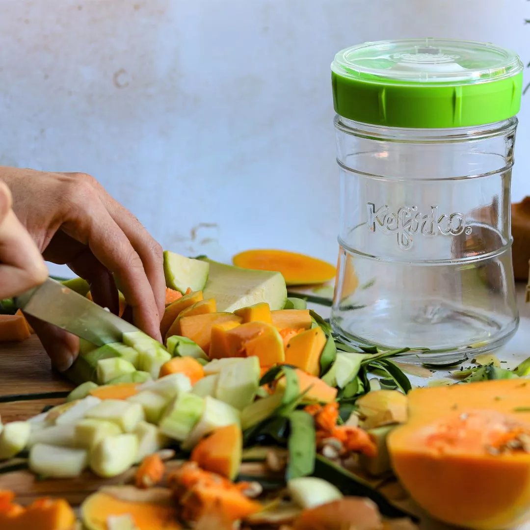 cortando verduras para preparar wisdom-kraut en kefirko fermentador de verduras verde