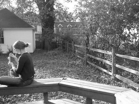 Knittedhome Annie knitting on a bench black and white