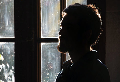 Backlit man in a video call with face shadows