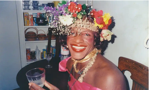 Marsha P. Johnson. A transgender woman wearing a flower crown and holding a cocktail