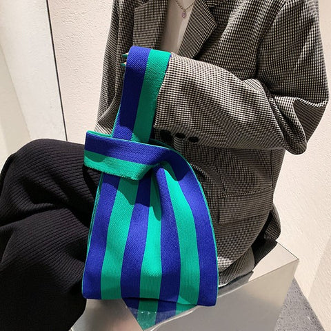 woman slinging a striped tote bag on her arms