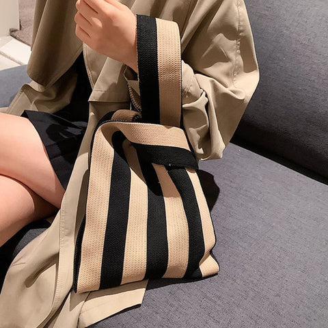 woman slinging a striped tote bag on her arms