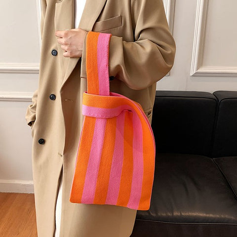 woman slinging a striped tote bag on her arms