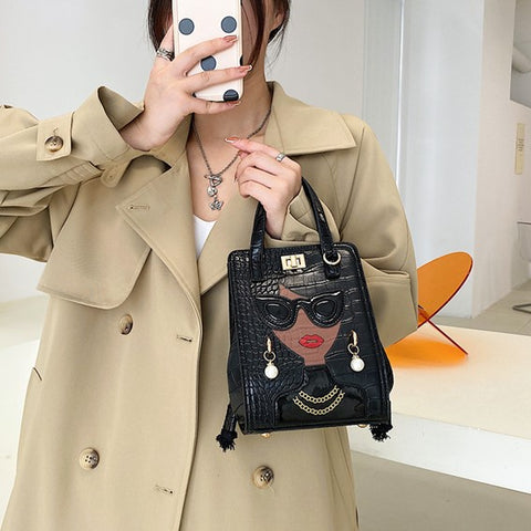 woman hand carries black unique purses, novelty purses, unique handbag, novelty bags, quirky handbag