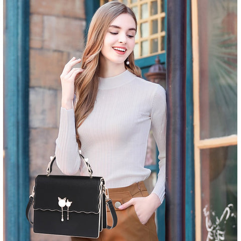 model hand carrying a black studded handle bag