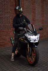 Motorradfahrer mit dunkler Kleidung und einem schwarzen AGV K2 Helm auf einer Suzuki GSXR1000