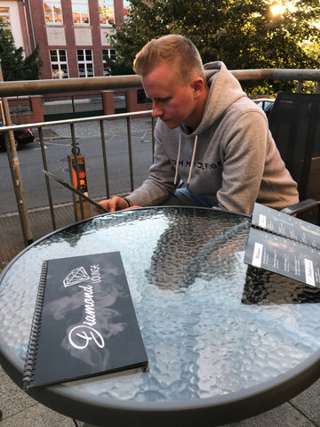 ein junger mann der an einem Tisch auf der Terrasse einer Shisha Bar sitzt. Diamond Lounge