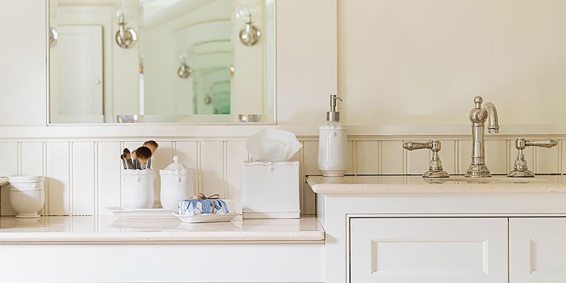 White bathroom vanity with Juliska countertop items.