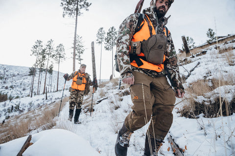 elk hunter hiking in snowy mountains