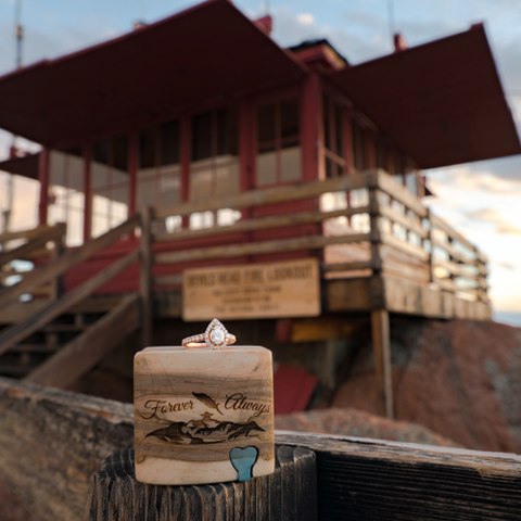 Engraved. wood ring box in front of fire watch tower