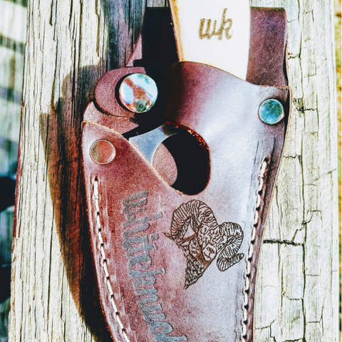 Leather knife sheath engraved with bighorn sheep sketch.
