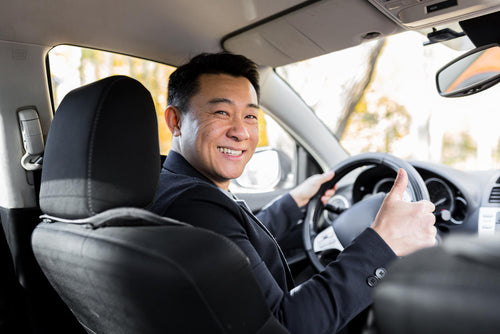 man-driving-asian-car-wheel-looks-camera-smiles.jpg__PID:665bbb5b-367b-4bc5-a975-d9ba92b5b16d