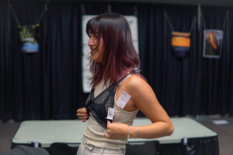 girl with red hair holding a singla nordic black bralette to her chest