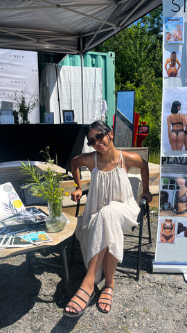 Girl in linen cottage core summer dress wearing a sustainable italian lace white bralette at the cottage lakeside dock sustainable small business pop up