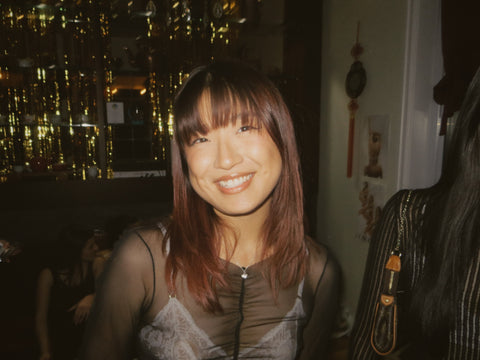 cindy shen wearing singla intimates ivory bralette under a sheer dress and red hair at the tea lounge