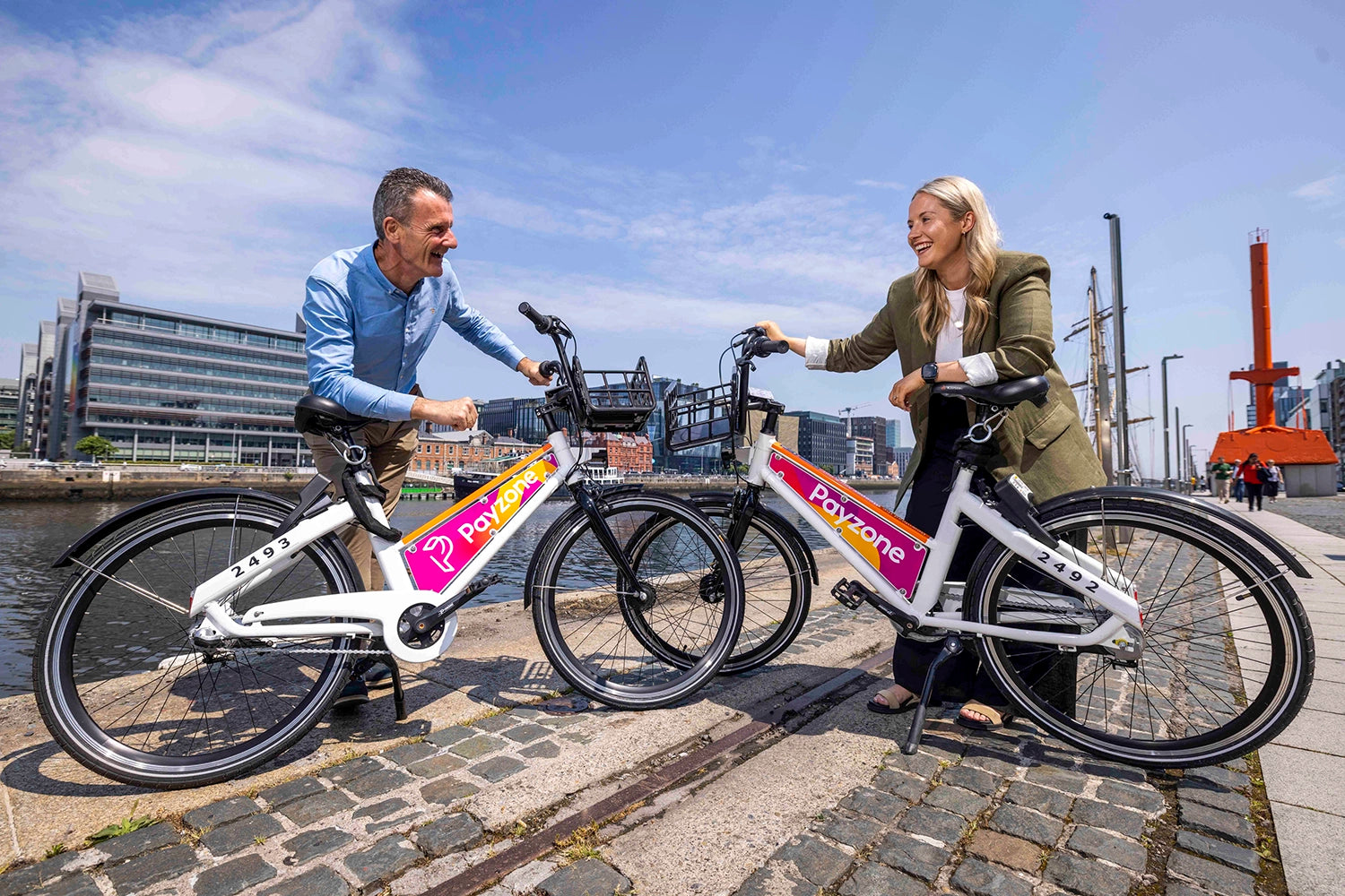 Jim Deignan, CEO of Payzone, and Ciara Donovan, Product Owner Parking Tag at Payzone Ireland, pictured in Dublin docklands with the newly branded Bleeper bikes. The Bleeper bikes have been branded with Payzone's logo on adboards on either side of the bikes. Bleeper is a public bike sharing service which operates across Dublin city.