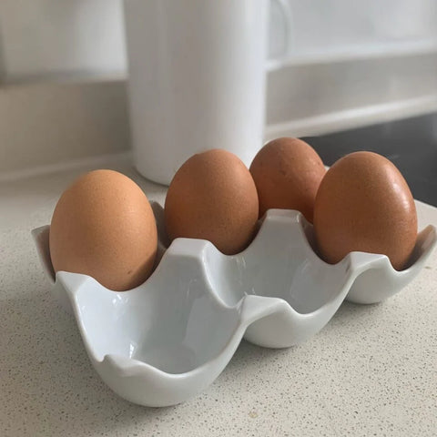 six piece ceramic egg holder with four eggs