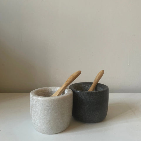 marble salt pot and a granite pepper pot with wooden spoons