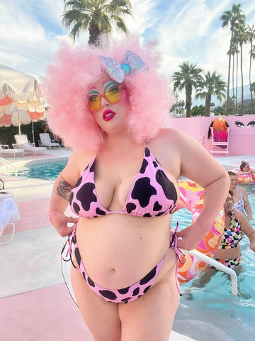 Plus size woman with pink hair wearing a string bikini.