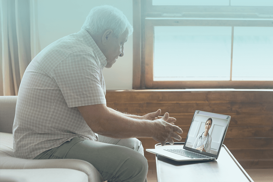 Elderly man on a telehealth conference on laptop computer.