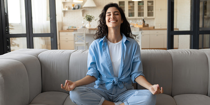 Relaxed woman smiling in a yoga pose after dosing CBD & CBG gummies for anxiety and stress.