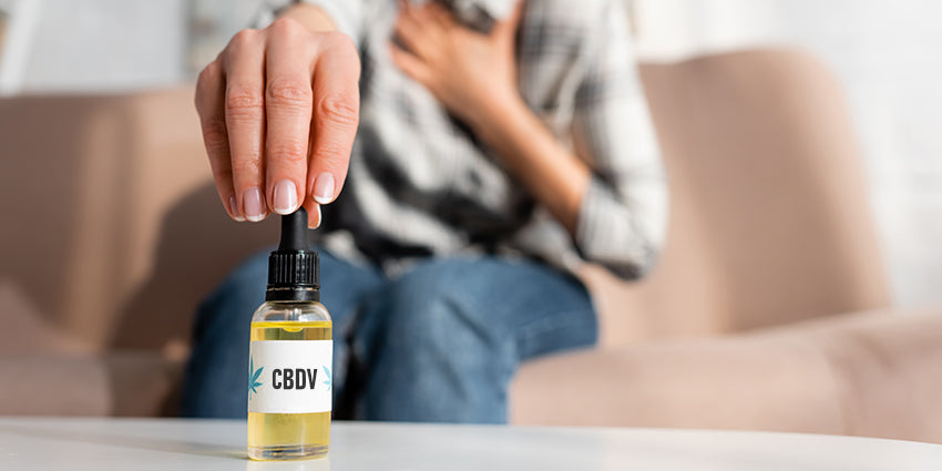 Woman dosing CBDV oil for energy. Buy CBD & CBDV gummies online in USA.