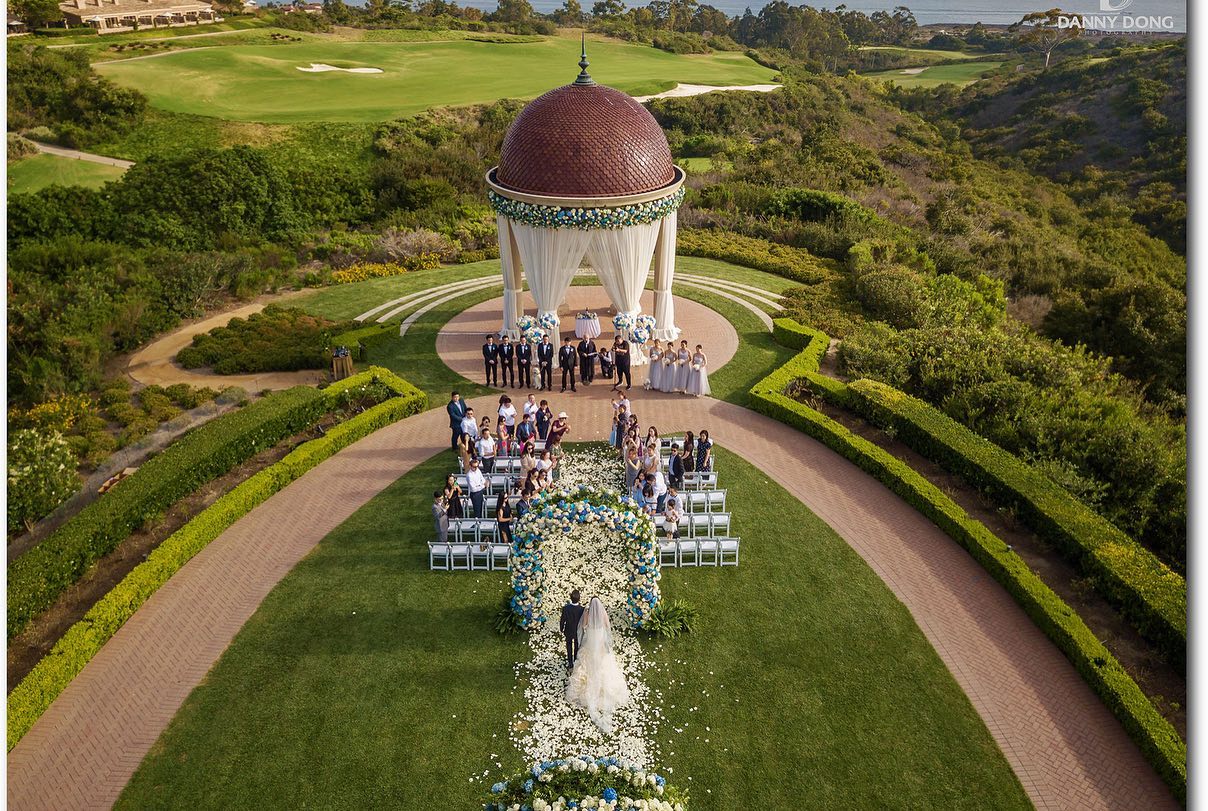 A bird's eye view of an outdoor wedding ceremony site as the bride walks down the aisle