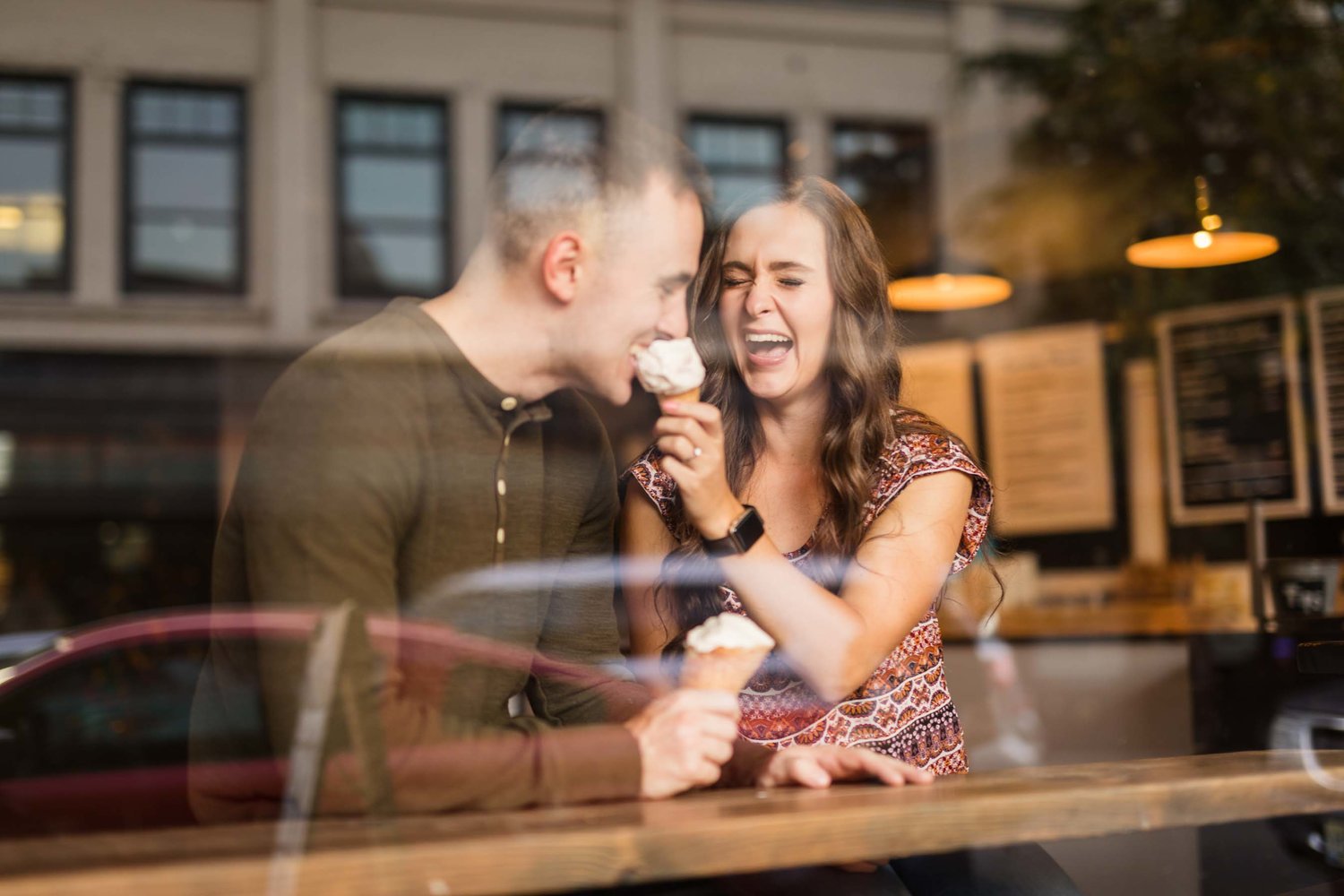 View of a couple through the window eating ice cream 