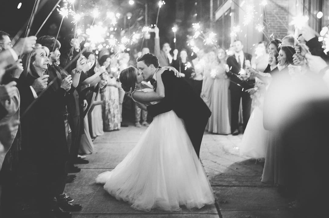 A bride and groom kissing during a sparkler exit post the wedding reception