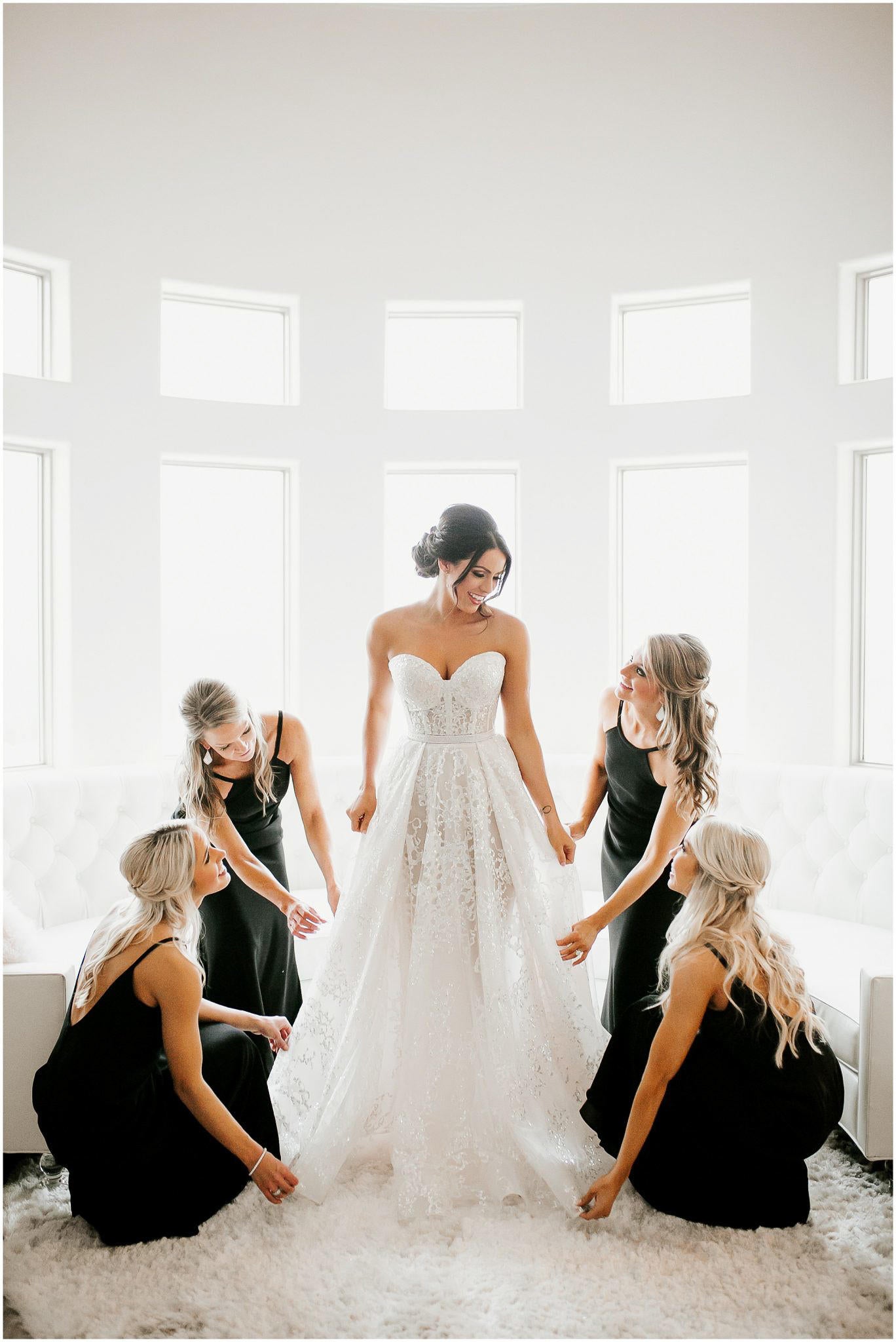bride getting ready surrounded by her bridesmaids wearing black
