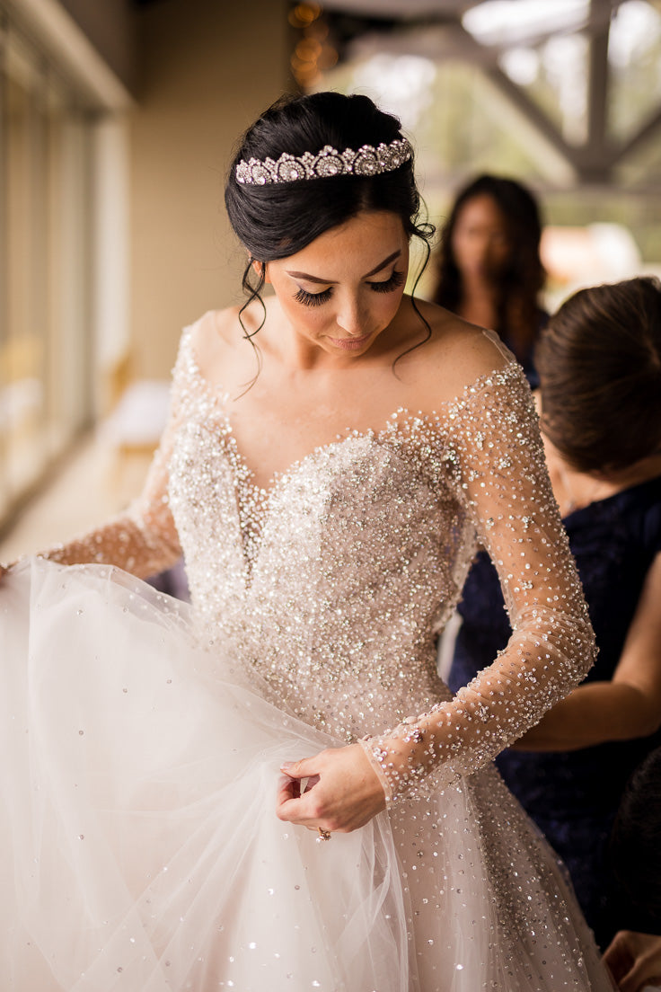 A bride holding her wedding gown during getting ready